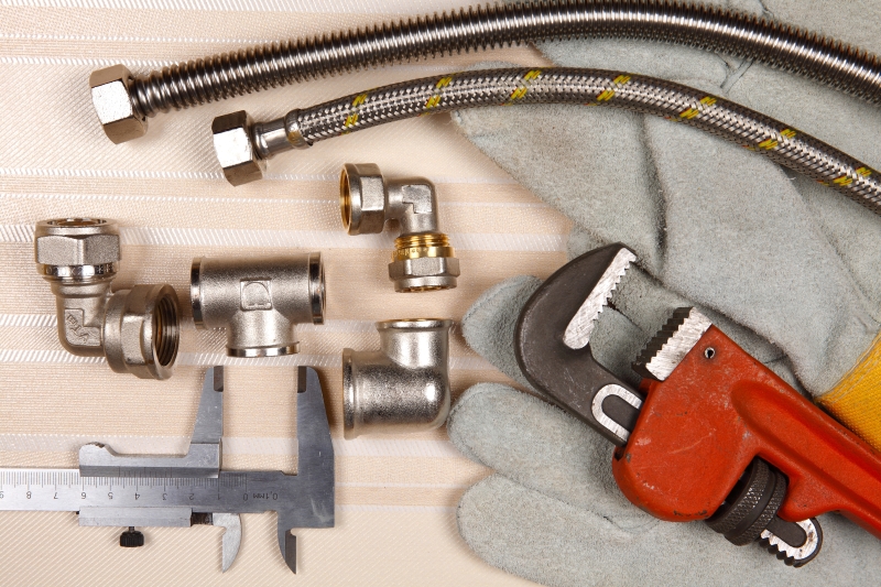 Plumber working on pipes in a Gidea Park home